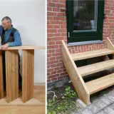 Man bygger en trappa utomhus. En färdigbyggd trappa leder upp till en dörr.