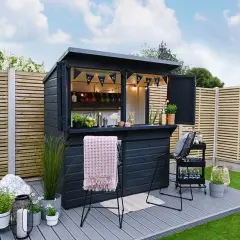 Svart utomhusbar med "GIN BAR"-girlang, redo för gäster. Perfekt för att bygga bar i trädgården.