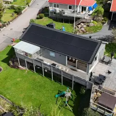 Hus med solceller på taket, en batteribank för energilagring, en lekplats och en bubbelpool.