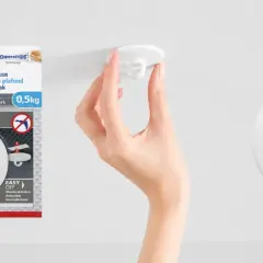 En hand fäster en vit krok i taket. Tesa Powerstrips-krok för tak, enkel att sätta upp och ta ner.