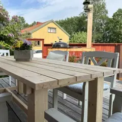 Bygga utebord: Enkla steg för att skapa ett robust utomhusbord. Trädetaljer, verktyg och ett färdigt bord i trädgården.
