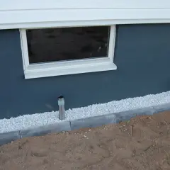 Nytt kantsten runt huset ger en fin avgränsning mot gruset och den mörka fasaden.