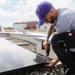 Installatör fäster solceller på taket. Rätt solceller riktning är avgörande för maximal energiproduktion.