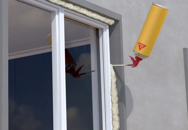 En gul burk med lågexpanderande fogskum appliceras runt ett fönster för isolering.