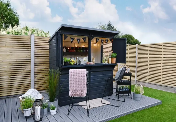 Svart utomhusbar med "GIN BAR"-girlang, redo för gäster. Perfekt för att bygga bar i trädgården.
