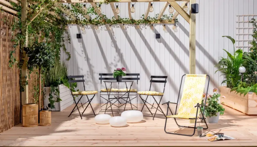 En mysig uteplats med pergola, möbler och växter. Perfekt för att bygga insynsskydd och njuta av sommaren.