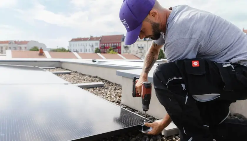 Installatör fäster solceller på taket. Rätt solceller riktning är avgörande för maximal energiproduktion.