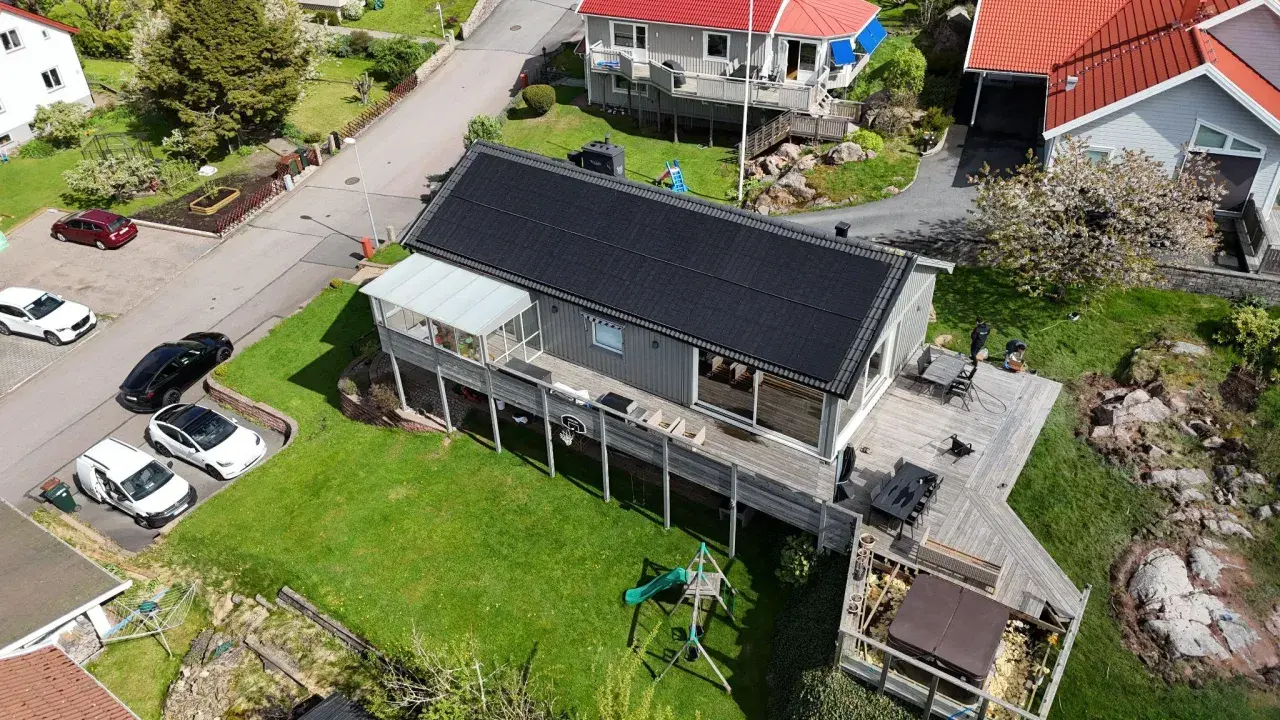 Hus med solceller på taket, en batteribank för energilagring, en lekplats och en bubbelpool.