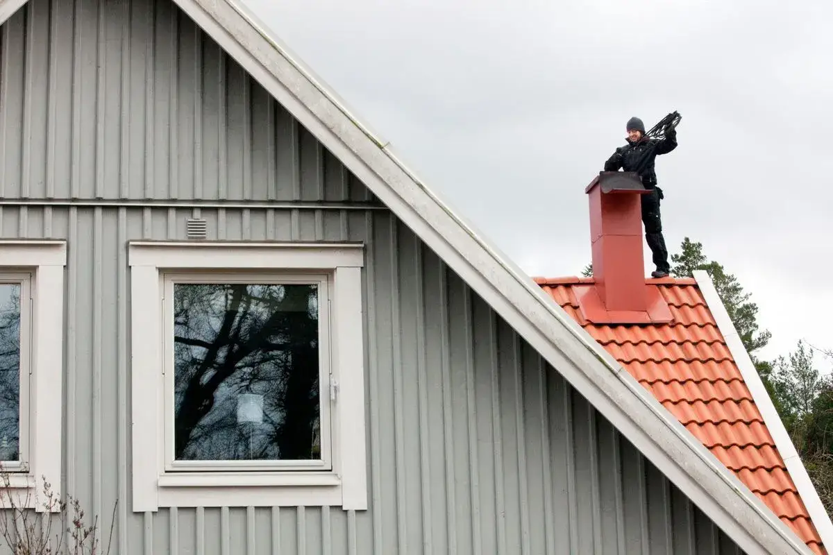 Sotare p&aring; taket till en villa, redo f&ouml;r sotning. Hur ofta en villa beh&ouml;ver sotning beror p&aring; eldstadens typ och anv&auml;ndning.
