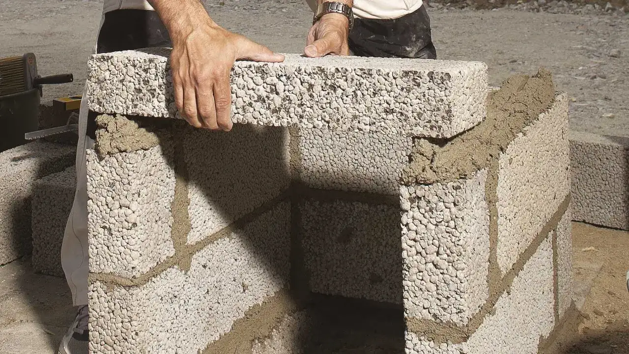 Byggare l&auml;gger en lecablock grund. Cement fogar samman blocken f&ouml;r en stabil konstruktion.