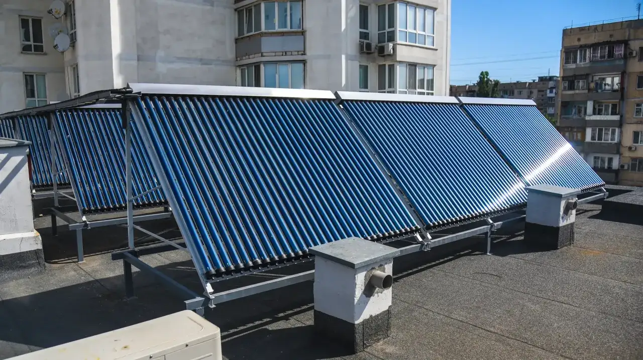 Solceller p&aring; ett tak v&auml;rmer upp vatten f&ouml;r en pool.